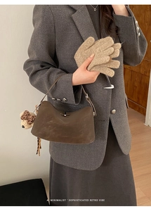 Minimalist retro style dark brown leather handbag with a plush bear charm detail