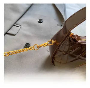 Close-up of premium gold metal hooks and quilted leather texture on a brown handbag