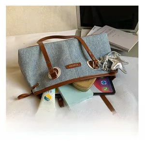 Intérieur spacieux du sac bowling en denim bleu contenant une tablette et des accessoires
