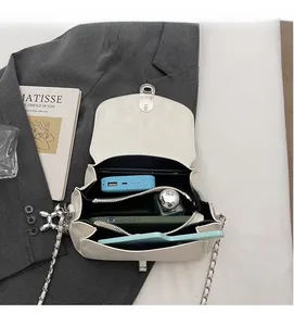 Vista dettagliata dell'interno multi-scomparto di questa borsa a tracolla bianca con catena