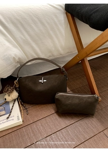 Detail of dark brown minimalist hobo bag set with plush charm in a cozy home setting