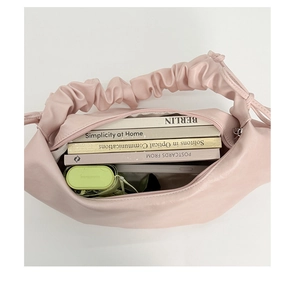 Internal view of pink pleated crossbody bag showing large capacity for books and daily items