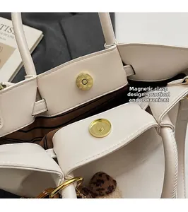 Détail du fermoir magnétique et de la doublure rayée de ce sac cabas en cuir crème