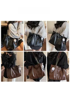 Detail view of large tote bags in black and brown featuring stylish gold chain straps