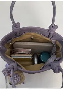 Detail view of large interior capacity of the purple leather bucket bag with items
