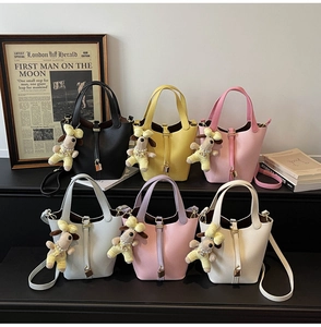 Selection of leather bucket bags in various colors with charming puppy charms and straps