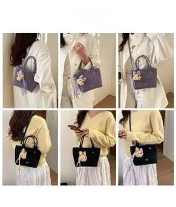 Detail showing various carrying styles of a bucket bag with bear pendant