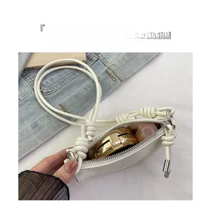 Détails de l'intérieur d'un sac selle blanc avec rangement maquillage et rouge à lèvres