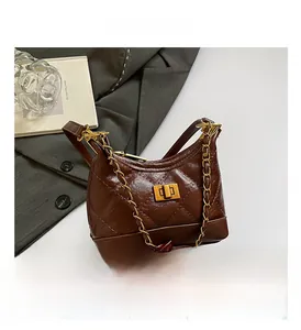 Close-up of brown quilted leather handbag with gold twist lock and chain strap
