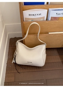 Detail of cream leather shoulder bag with side pocket and woven decorative rope