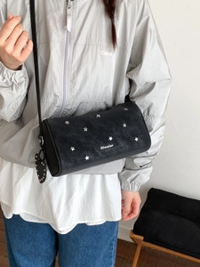 Sac cylindrique noir tendance avec rivets étoiles argentés et breloque coeur élégante
