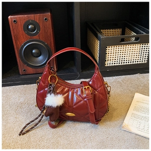 Deep red quilted leather handbag with gold chain strap and decorative charms detail