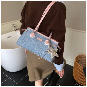 Détail du sac bowling en jean avec bordure en cuir rose et pendentif étoile