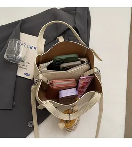 Intérieur spacieux du sac seau crème avec rangement pour téléphones et portefeuille