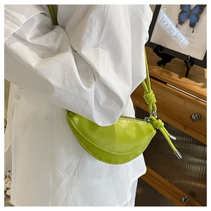 Détail du sac selle croissant vert vif avec bandoulière stylée à nœuds décoratifs