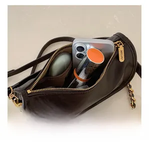 Internal view showing capacity of dark brown cylinder chain bag with gold hardware