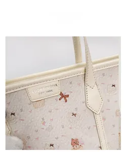 Dettaglio della borsa in ecopelle color crema con stampe carine e targhetta del brand