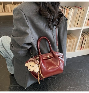 Détail du sac cabas bordeaux avec breloque chiot en peluche et nœud léopard
