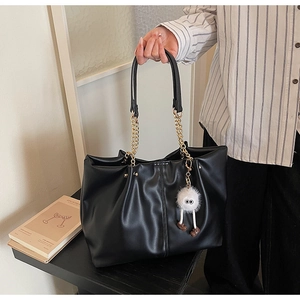 Close-up of black PU leather tote bag with pleated design and golden chain handle detail
