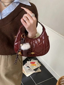 Chic burgundy crescent handbag with quilted pattern and cute glove charm accessory