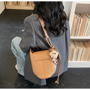 Brown lychee leather crossbody bag with a cute bear plush and pearl chain detail