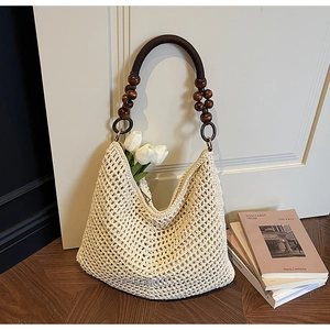 Detail of hollow knit hobo bag with wooden bead handle and vintage woven texture
