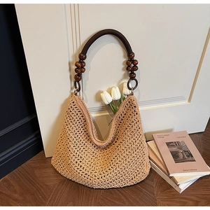 Detail of hand-woven hollow knit tote bag with decorative dark brown wooden beads