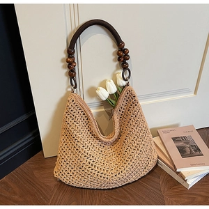 Detail of hollow knit tote bag featuring zipper closure and decorative dark wood beads