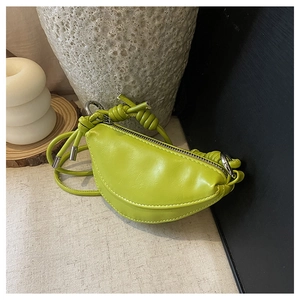 Détail du sac selle vert citron avec bandoulière nouée et texture en PU lisse