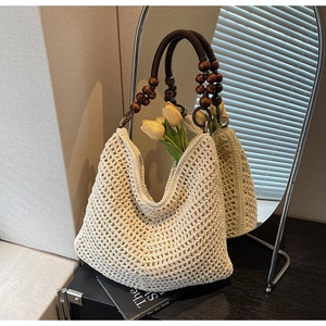 Detail of crochet knit tote with hollow texture and vintage wooden bead handle with tulips