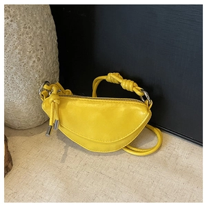 Détail du sac demi-lune jaune avec une poignée tressée unique et des ferrures argentées
