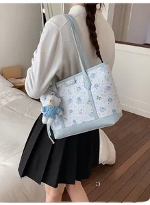 Dettaglio della borsa tote stampata blu e bianca con un simpatico ciondolo a orsetto