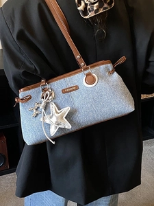 Borsa bowling chic in denim con finiture in pelle e ciondoli a stella a tracolla