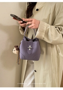 Détail du sac seau violet avec boucle argentée et pendentif chien en peluche doux