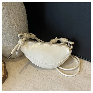 Vue détaillée d'un mini sac demi-lune crème avec cuir texturé et nœuds décoratifs