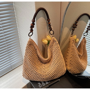 Detail of hollow knit beach tote with dark wooden bead accents and woven handles