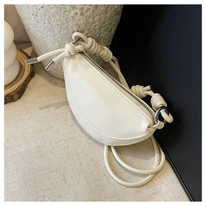 Détail d'un sac bandoulière blanc demi-lune montrant le cuir PU lisse et la sangle nouée