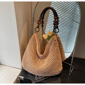 Detailed view of beige hollow knit tote bag featuring a vintage wooden ring handle