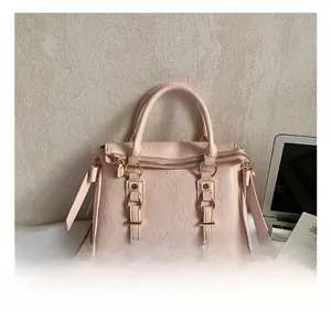 Dettaglio della borsa rosa con texture stropicciata e anelli metallici dorati decorativi