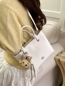 Chic white leather bucket tote bag with GG logo and cute plush teddy bear charm