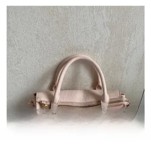 Dettaglio della borsa tote rosa a pieghe con cerniera dorata e finiture metalliche