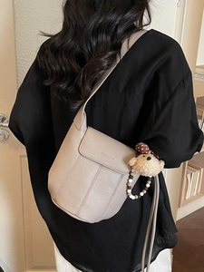 Vintage light beige bucket shoulder bag in pebble leather with a cute plush bear charm