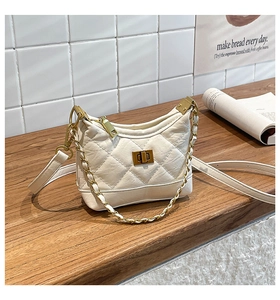 Detail of off-white quilted chain bag with gold twist lock and crinkled leather texture