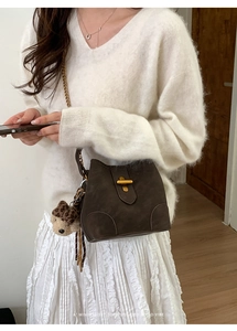 Détail du sac seau rétro marron foncé avec fermoir doré mat et breloque léopard stylée