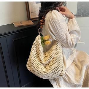 Detail of hollow knit shoulder bag featuring vintage dark brown wooden bead straps