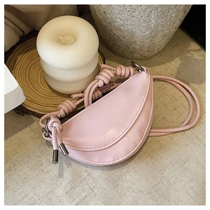 Détail du sac demi-lune rose clair avec bandoulière nouée ajustable et détails argentés