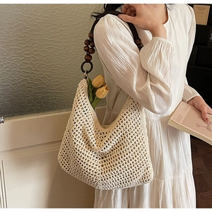 Close-up of hollow knit tote bag with decorative dark brown wooden bead handle straps