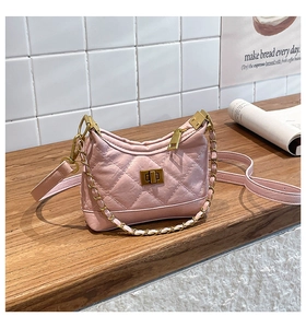 Close-up of pink quilted PU leather handbag with golden twist lock and chain strap
