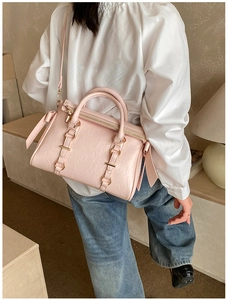 Dettaglio della borsa tote rosa a pieghe con hardware dorato e decorazione con fiocco