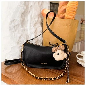 Chic black crescent bag with chunky gold chain and cute brown bear charm detail